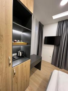 a room with a bed and a kitchen with a tv at OLYMPIC 84 Apartments in Sarajevo