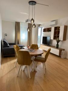 - un salon avec une table, des chaises et un canapé dans l'établissement Apartman ARIA, à Zagreb