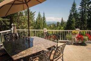 a table and chairs with an umbrella on a balcony at Coeur de Lion BNB in Coeur d'Alene