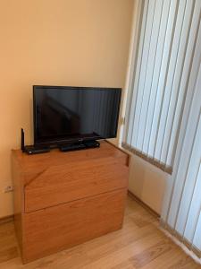 una TV a schermo piatto seduta sopra un comò in legno di Like Home Guest Rooms a Sofia