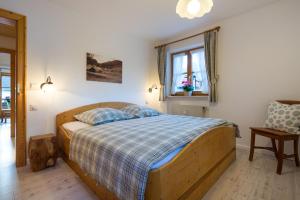 a bedroom with a wooden bed with a blue and white blanket at Ferienwohnungen Alpentraum - Pusteblume in Obermaiselstein