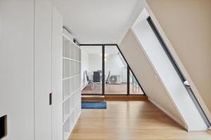 una escalera en una casa con paredes blancas y suelo de madera en Florian's apartments in Mariahilf Vienna en Viena