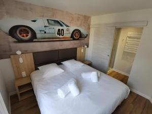 een slaapkamer met een bed met een auto aan de muur bij Malicorn' Appart-Hôtel in Malicorne-sur-Sarthe