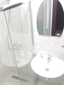 W białej łazience znajduje się umywalka i lustro. w obiekcie Casa Sura Sasilor w Sybinie