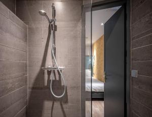 Un baño con ducha con puerta de cristal. en Musea Hotel & Apartments, en Ámsterdam