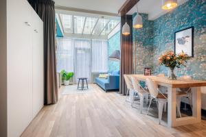 Una sala de estar con una mesa y un sofá azul. en Musea Hotel & Apartments, en Ámsterdam