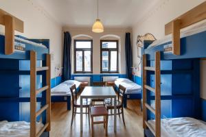 a room with bunk beds and a table and chairs at Hostel Mondpalast in Dresden