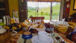 a table with a bunch of different types of bread at Pousada Campestre Cunha-SP in Cunha