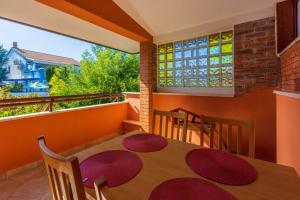 a dining room with a table and chairs on a balcony at Apartments villa MaVeRo in Banjole