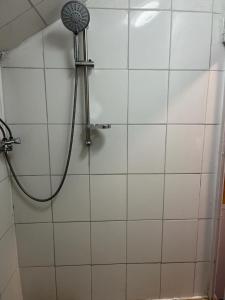 a shower with a shower head on a white tiled wall at Monteurzimmer bei EnergyFreund in Knetzgau