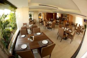 Heaven Prestige Hotel في جونية: مطعم بطاولات وكراسي خشبية في الغرفة