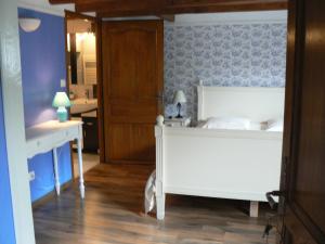 ein Schlafzimmer mit einem weißen Bett und einem Waschbecken in der Unterkunft La Maison de l'Etang in Sampigny