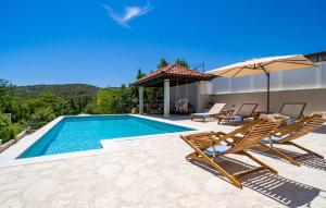 a swimming pool with two chairs and an umbrella at Villa Doli - Lovely holiday home with private pool in Doli
