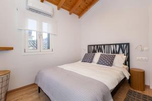 a white bedroom with a bed with blue pillows at Nona´s Dorf Haus in Liapades in Liapades