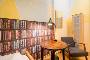 a room with a table and a wall of books at Hostel Mondpalast in Dresden