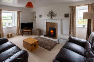 a living room with a couch and a fireplace at The Croft Cottage - near Aviemore in Aviemore