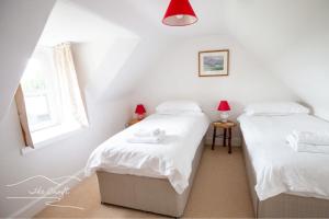 two twin beds in a room with a window at The Croft Cottage - near Aviemore in Aviemore