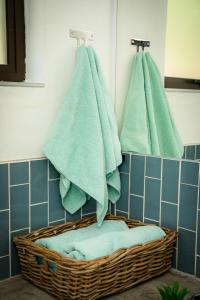 a bathroom with green towels in a basket at Rock House at Benlize in Hartbeespoort