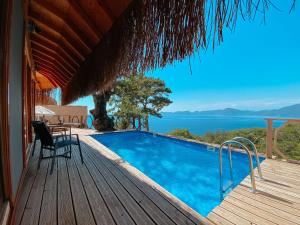 a house with a swimming pool on a wooden deck at Heaven Resort Faralya in Faralya