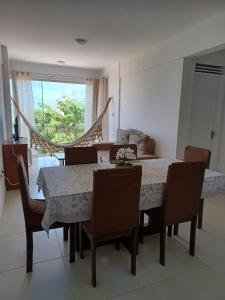 a dining room with a table and chairs and a window at Apartamento em Camboinha in João Pessoa