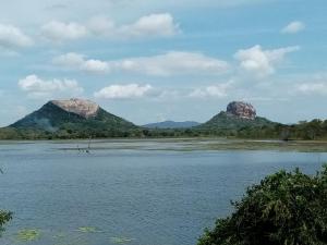 uma vista para um rio com montanhas ao fundo em Jungle Edge Home Sigiriya em Sigiriya