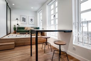 cocina y sala de estar con mesa negra y taburetes en housingcoruña ELKEL en A Coruña