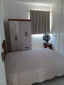 a bedroom with a white bed and a curtain at Apartamento em Camboinha in João Pessoa