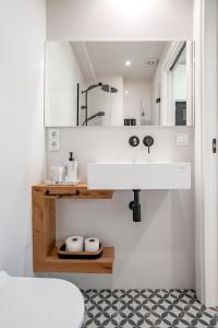 y baño con lavabo blanco y espejo. en housingcoruña ELKEL en A Coruña