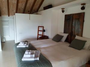 una camera con due letti e asciugamani di Bed and breakfast Casa d'Oliveiral - Adults Only a Aguda