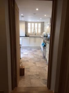 a kitchen with white cabinets and a tile floor at River Road, Littlehampton, Executive Apartment in Littlehampton