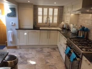 a kitchen with white cabinets and a stove top oven at River Road, Littlehampton, Executive Apartment in Littlehampton