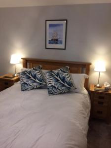 a bedroom with a white bed with two pillows on it at River Road, Littlehampton, Executive Apartment in Littlehampton
