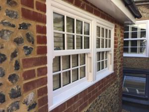 two windows on the side of a brick building at River Road, Littlehampton, Executive Apartment in Littlehampton