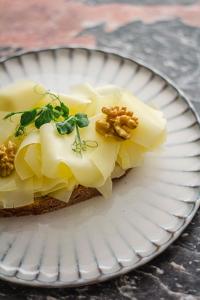 a piece of bread with cheese and nuts on a plate at Kai 36 - Hotel zwischen Fels und Fluss in Graz