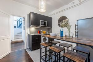 a kitchen with a counter with stools and a table at Sweet Inn - Friedland in Paris