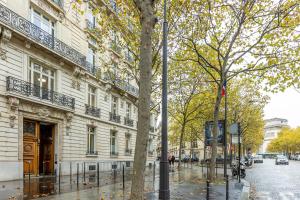 a building on a city street with trees in front of it at Sweet Inn - Friedland in Paris