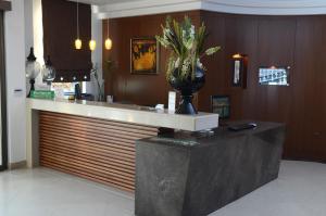 a bar in a restaurant with a vase of flowers on a counter at Danai Hotel & Spa in Olympic Beach