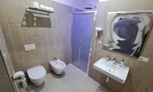 a bathroom with a toilet and a sink and a shower at Hera Tropea Rooms in Tropea