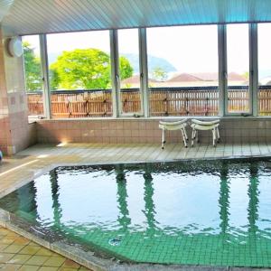 a swimming pool with a bench in a house at Kyukamura Ohmi-Hachiman in Omihachiman