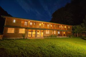 a large building with lights on in a yard at Natural e Simplu in Petroşani