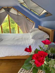 sypialnia z łóżkiem z czerwonymi różami na stole w obiekcie Ralph's Barn w mieście Newport