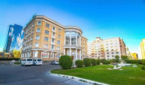 a large building with cars parked in front of it at Continental Hotel in Ulaanbaatar