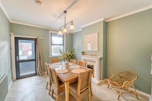 uma sala de jantar com uma mesa e cadeiras e uma lareira em Guest Homes - Barton Road House em Hereford