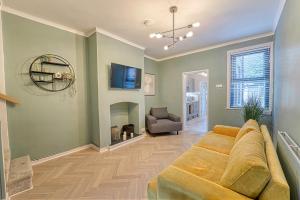uma sala de estar com um sofá e uma lareira em Guest Homes - Barton Road House em Hereford