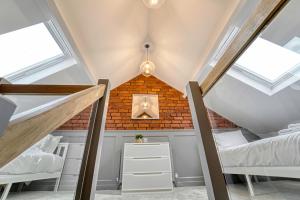 a attic bedroom with two beds and a brick wall at Guest Homes - Barton Road House in Hereford