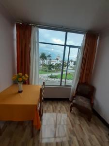 a dining room with a table and a large window at Hotel Central in Latacunga