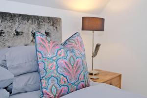 a bed with a pillow and a table with a lamp at The Loft in Stonehaven