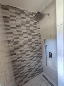 a bathroom with a shower with a tiled wall at House Bozovic in Žabljak