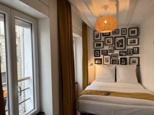 sypialnia z łóżkiem i ścianą z obrazami w obiekcie Villette & Canal - Apartment w Paryżu