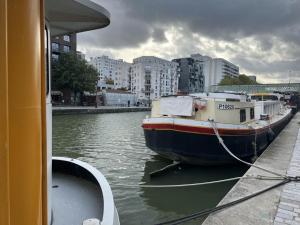 Łódź zakotwiczona jest w doku w wodzie w obiekcie Villette & Canal - Apartment w Paryżu